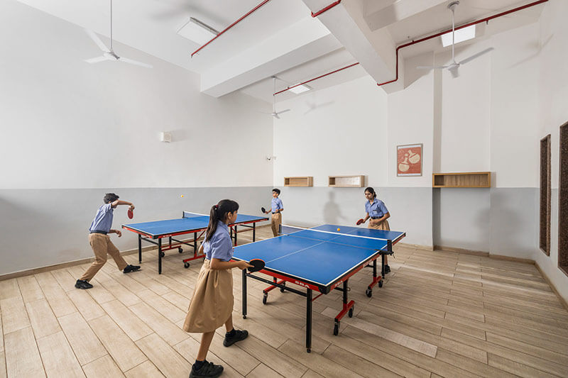 Students playing table tennis in the indoor sports room at BLS World School Greater Noida West